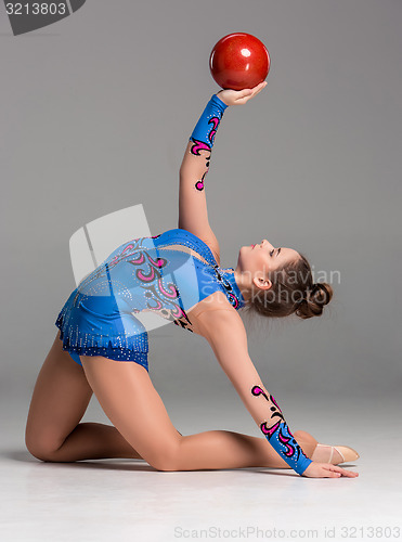 Image of teenager doing gymnastics exercises with red gymnastic ball