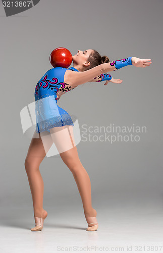 Image of teenager doing gymnastics exercises with red gymnastic ball