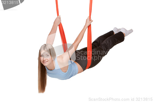 Image of Young woman doing anti-gravity aerial yoga