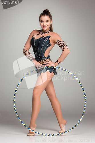 Image of teenager doing gymnastics exercises with colorful hoop