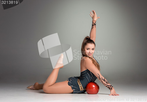 Image of teenager doing gymnastics exercises with red gymnastic ball