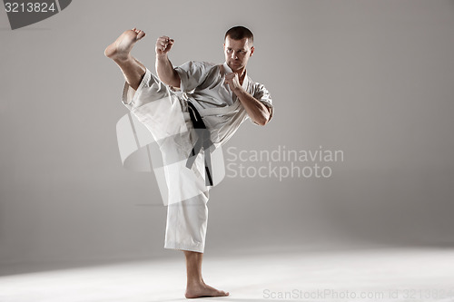 Image of Man in white kimono training karate