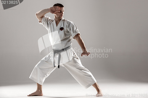 Image of Man in white kimono training karate
