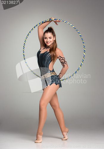 Image of teenager doing gymnastics exercises with colorful hoop