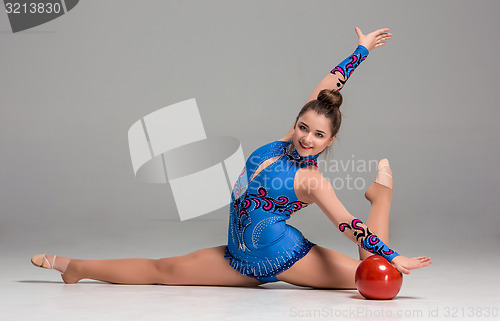 Image of teenager doing gymnastics exercises with red gymnastic ball