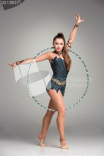 Image of teenager doing gymnastics exercises with colorful hoop