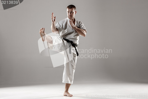 Image of Man in white kimono training karate