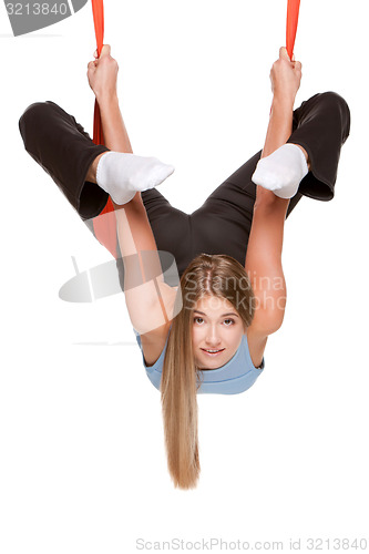 Image of Young woman doing anti-gravity aerial yoga