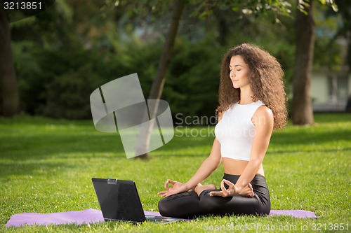 Image of Meditating woman with laptop