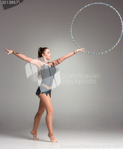 Image of teenager doing gymnastics exercises with colorful hoop