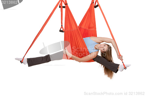 Image of Young woman making antigravity yoga exercises in stretching twine