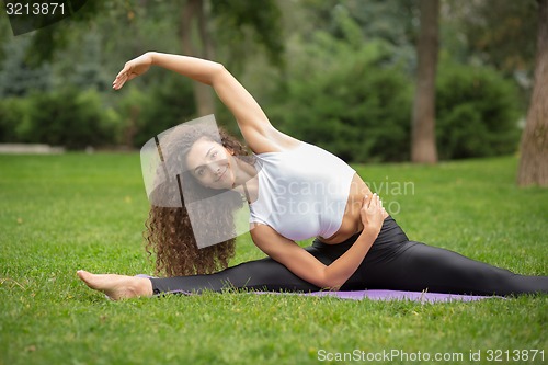 Image of Pretty woman doing yoga exercises 