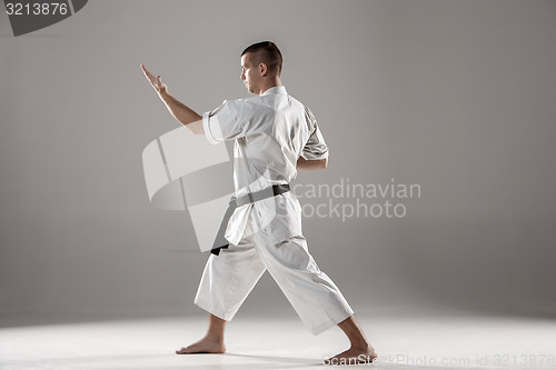 Image of Man in white kimono training karate