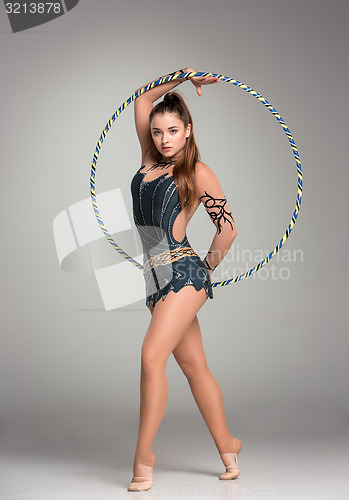 Image of teenager doing gymnastics exercises with colorful hoop