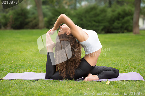 Image of Pretty woman doing yoga exercises 