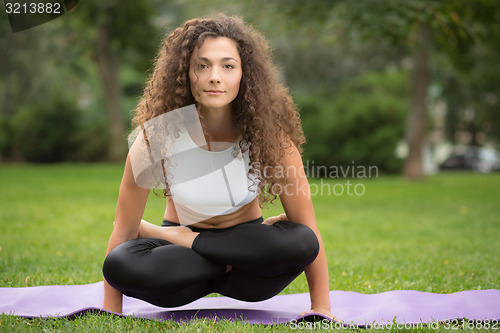 Image of Pretty woman doing yoga exercises 