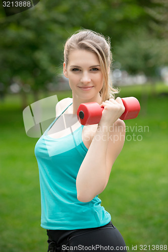 Image of Sports girl exercise with dumbbells in the park