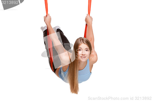 Image of Young woman doing anti-gravity aerial yoga