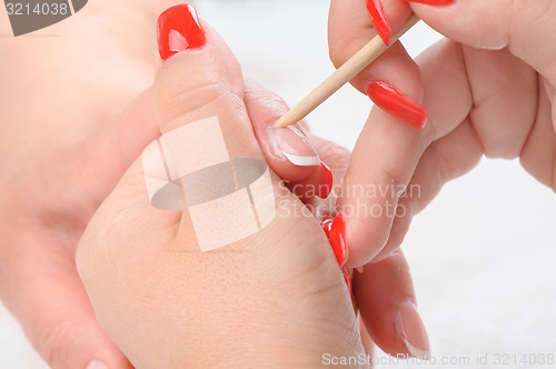 Image of manicure applying - cleaning the cuticles 