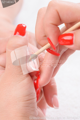 Image of manicure applying - cleaning the cuticles 