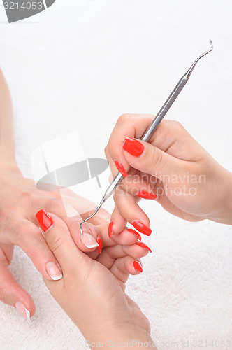 Image of manicure applying - cleaning the cuticles 