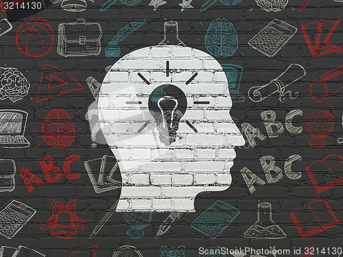 Image of Education concept: Head With Light Bulb on wall background