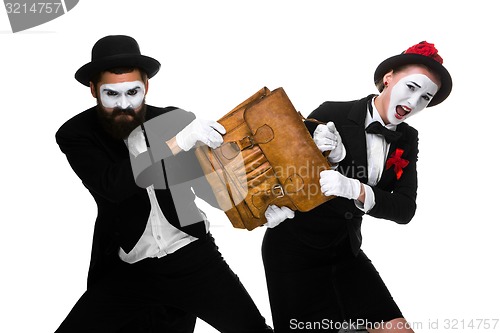 Image of Business man and woman fighting over briefcase