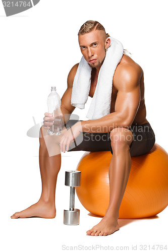 Image of Shaped and healthy body man sitting on fitness ball 