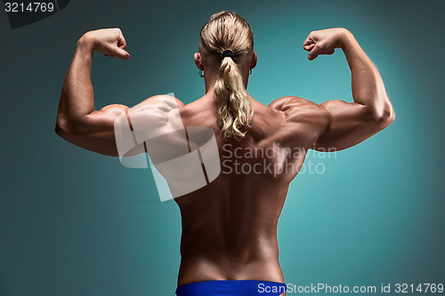 Image of Attractive male body builder on blue background