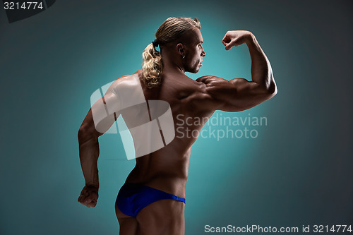 Image of Attractive male body builder on blue background