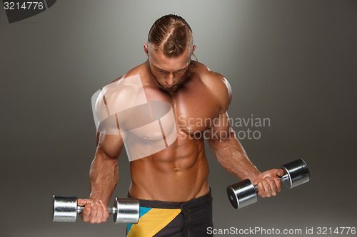 Image of Attractive male body builder on gray background