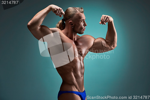 Image of Attractive male body builder on blue background