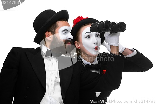 Image of Two memes as business people looking through binoculars 
