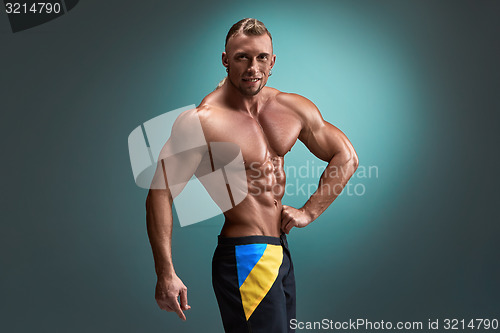 Image of Attractive male body builder on blue background