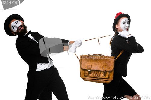 Image of Business man and woman fighting over briefcase