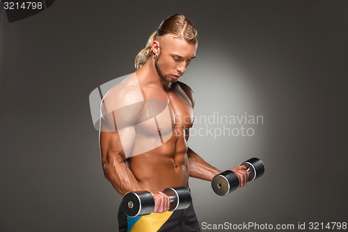 Image of Attractive male body builder on gray background