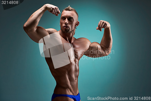 Image of Attractive male body builder on blue background