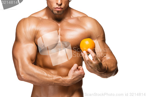 Image of Shaped and healthy body man holding a fresh orange fruit,  isolated on white background