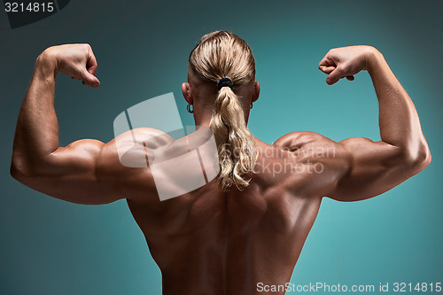 Image of Attractive male body builder on blue background