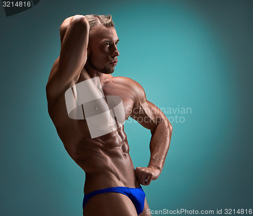 Image of Attractive male body builder on blue background