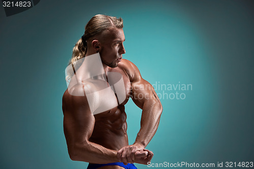 Image of Attractive male body builder on blue background