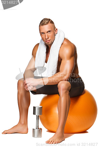 Image of Shaped and healthy body man sitting on fitness ball 