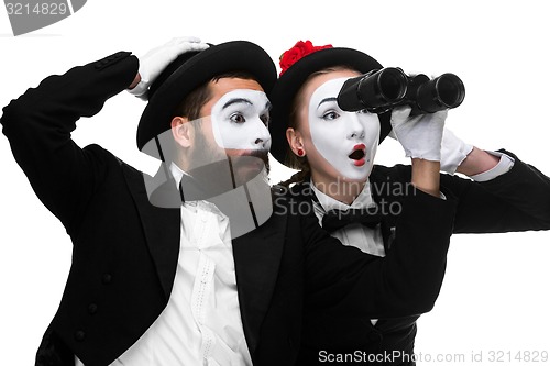 Image of Two memes as business people looking through binoculars 