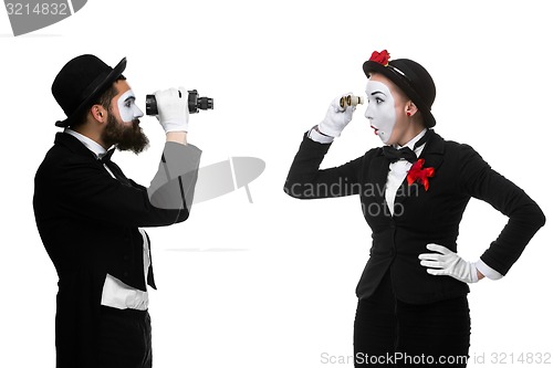 Image of Two memes as business people looking at each other through binoculars 