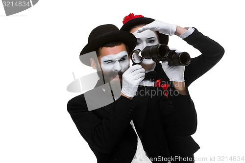 Image of Two memes as business people looking through binoculars 