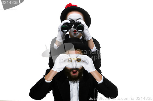 Image of Two memes as business people looking through binoculars 