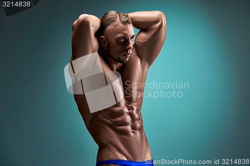 Image of Attractive male body builder on blue background