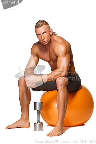 Image of Shaped and healthy body man sitting on fitness ball 