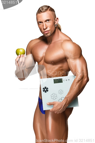 Image of Shaped and healthy body man holding a fresh apple,  isolated on white background