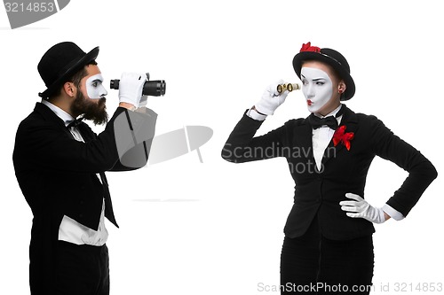 Image of Two memes as business people looking at each other through binoculars 